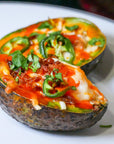 Sauce Boss Gang dinner ideas with garlic habanero hot sauce on a baked avocado.