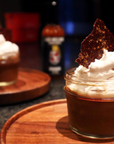 Chocolate dessert with whipped cream and a tortilla chip on a wooden surface