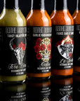 Row of Sauce Boss hot sauce bottles with various labels on a reflective surface.