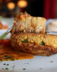 Fried dish with a creamy topping on a white plate with a blurred background