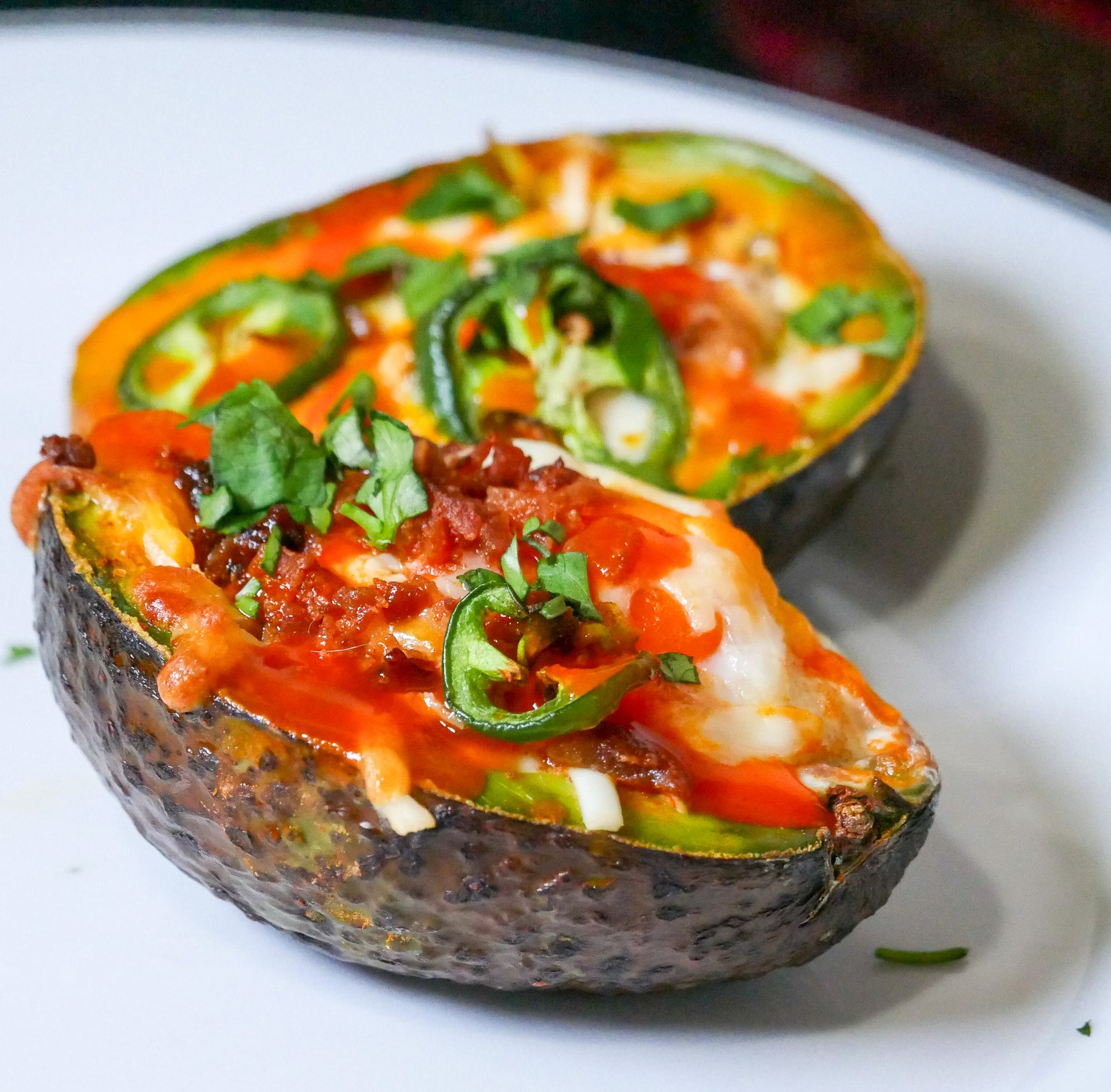 Sauce Boss Gang dinner ideas with garlic habanero hot sauce on a baked avocado.