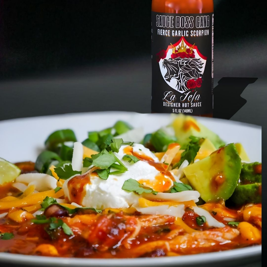 Plate of food with a bottle of La Jefa hot sauce in the background