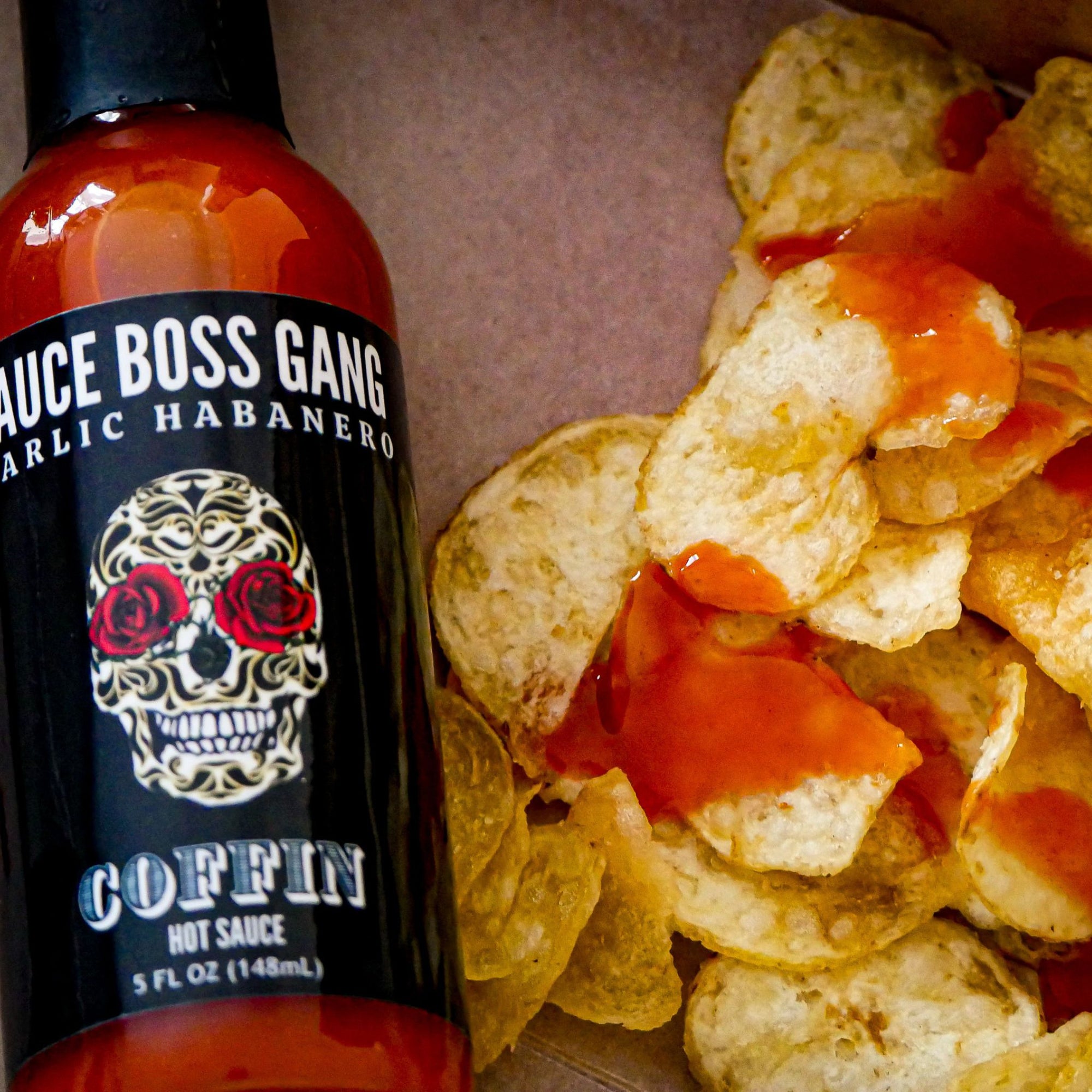 Sauce Boss Gang Garlic habanero hot sauce on potato chips.