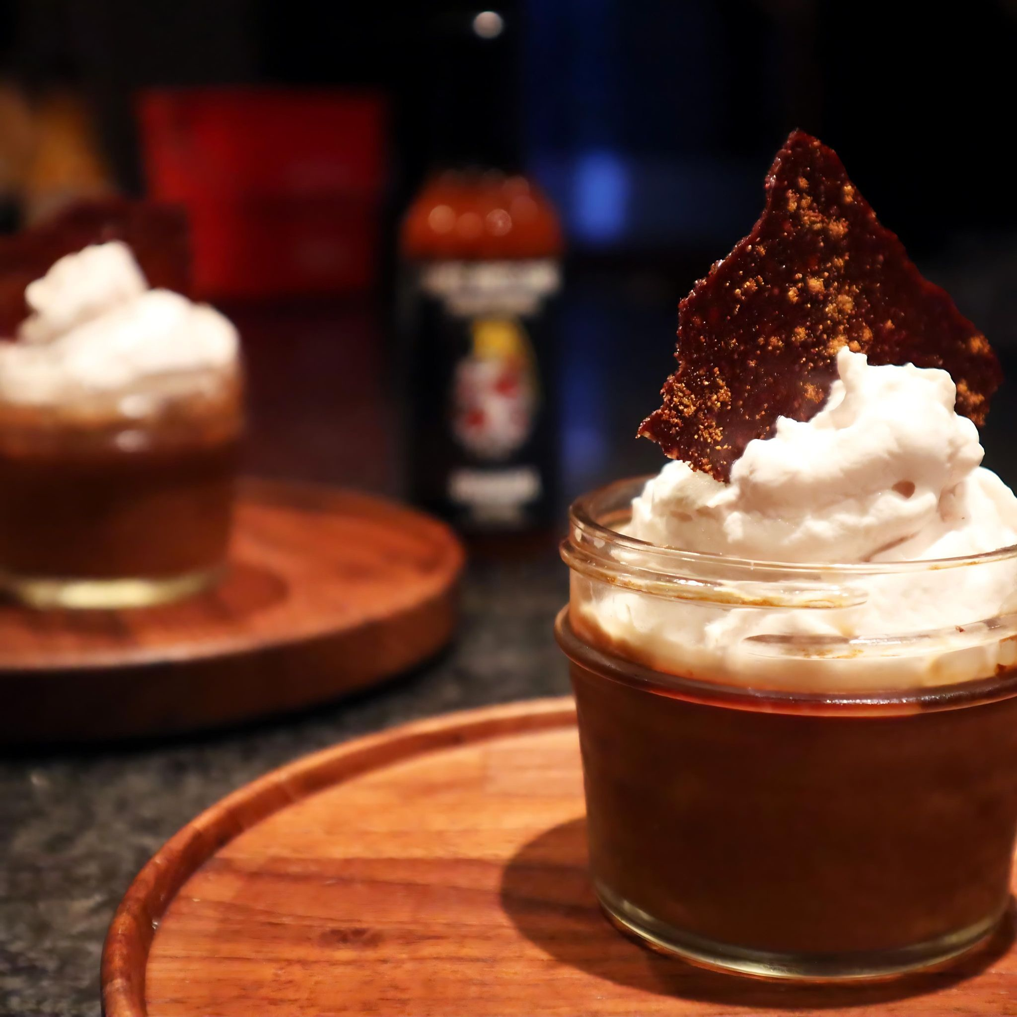 Chocolate dessert with whipped cream and a tortilla chip on a wooden surface