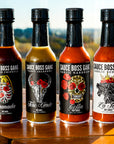 The Whole Gang hot sauce collection on a table, close up view.