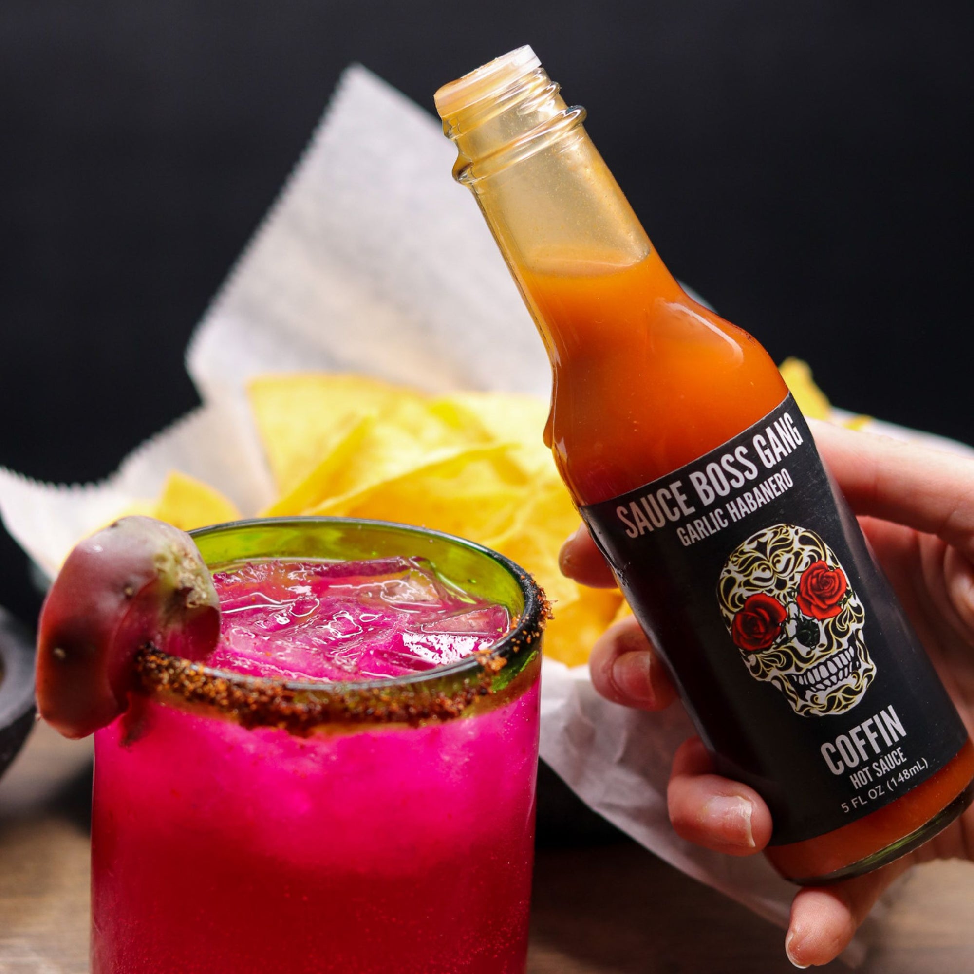 Sauce Boss Gang garlic habanero hot sauce in a pink dragonfruit margarita.