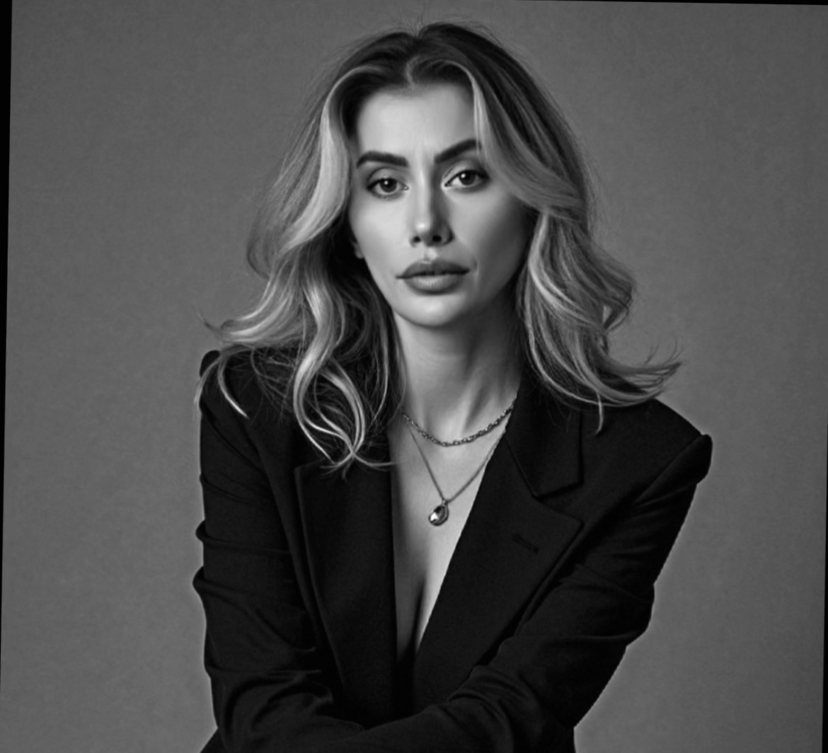 Black and white portrait of a woman wearing a black blazer against a gray background
