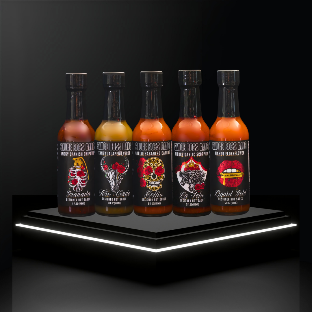 Five bottles of hot sauce with colorful labels on a black platform with LED lighting.