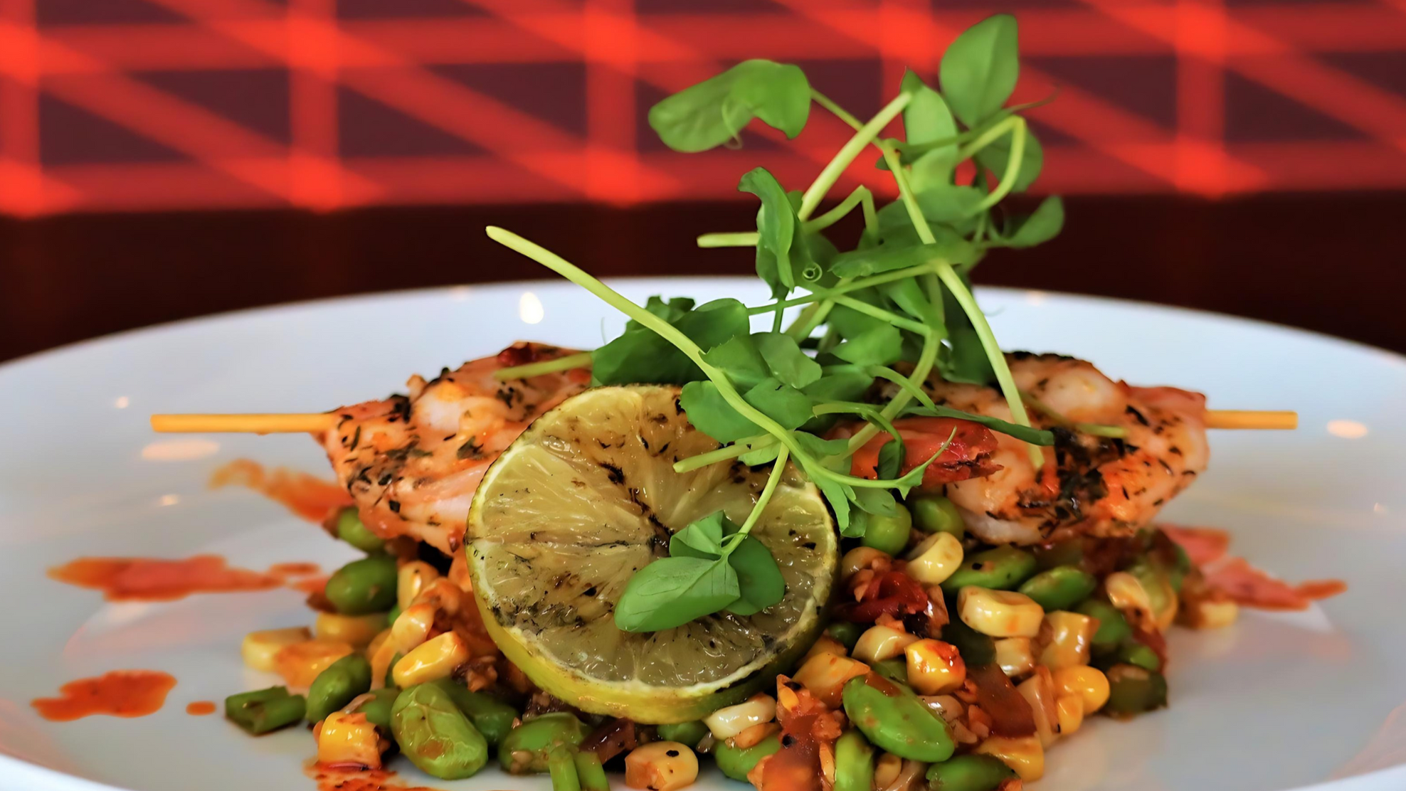 Sauce Boss Gang garlic habanero hot sauce over shrimp skewers with lime.