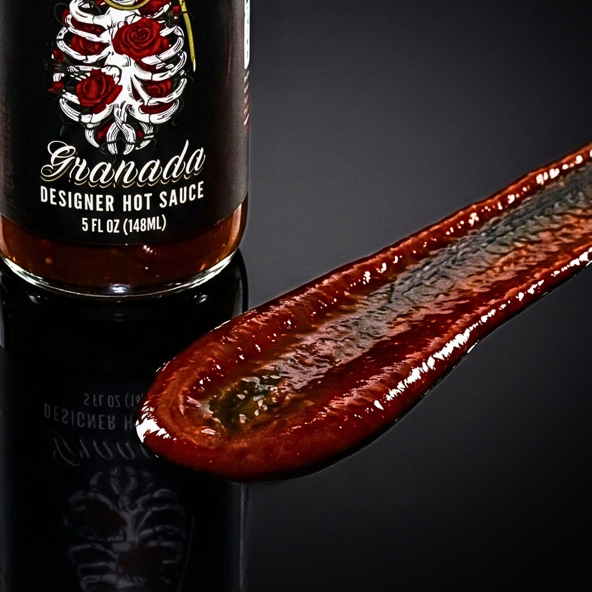 Hot sauce bottle with a label featuring roses and the brand name 'Granada' on a dark background.