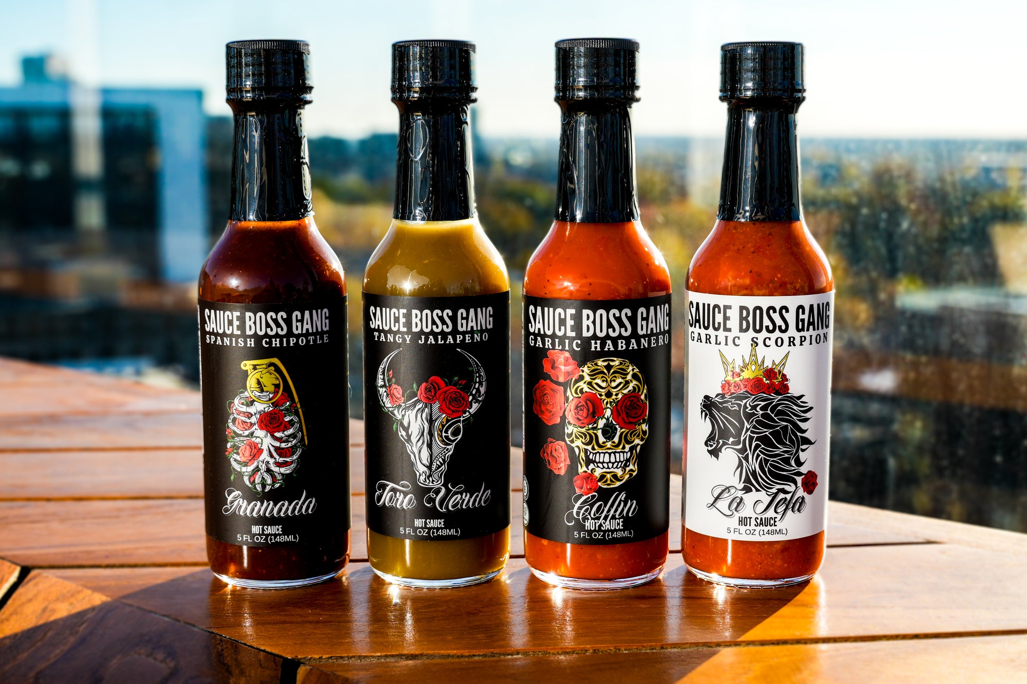 Sauce Boss Gang "Whole Gang " hot sauce collection on a table in the sunlight.