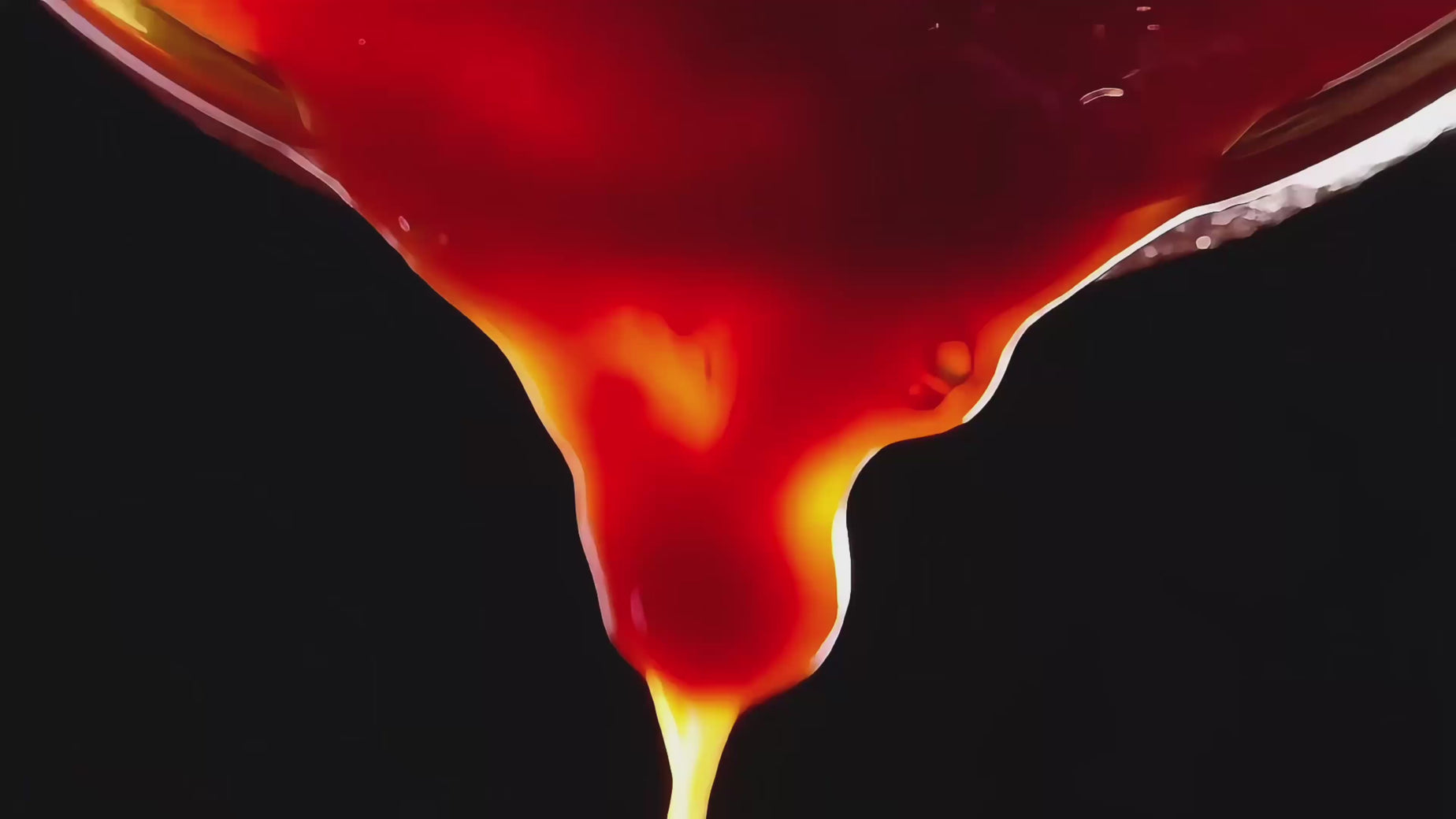 Up close video of sauce being poured, spice falling from the frame and a woman eating saucy chicken wings.
